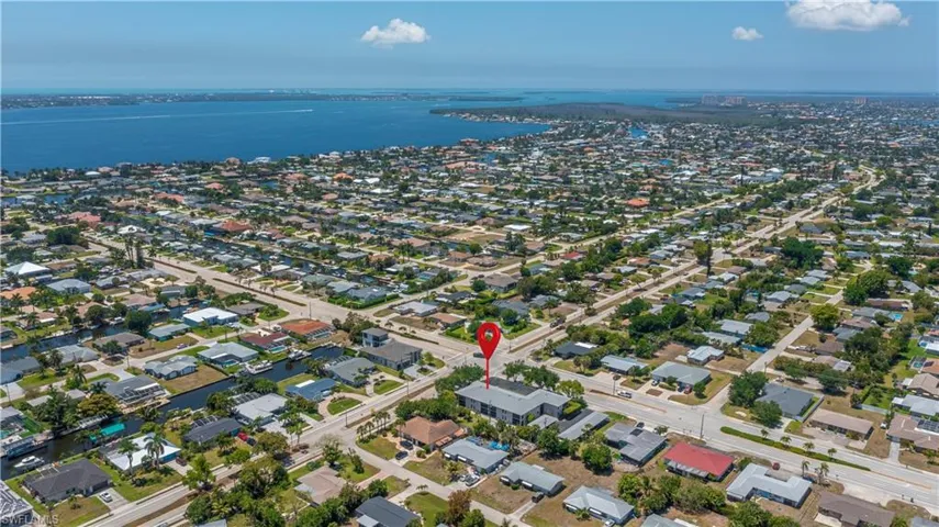 Aerial perspective showcasing a residential neighborhood with a prominent body of water in the background