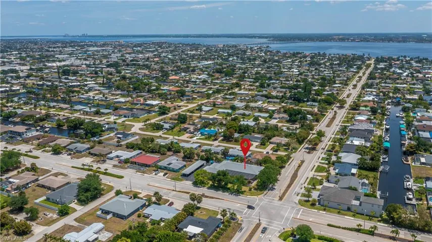 Aerial perspective of a residential community featuring waterways and distant open water