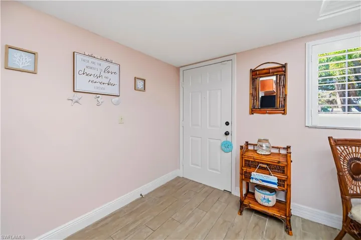 Entryway featuring wood-finish flooring and a white paneled door