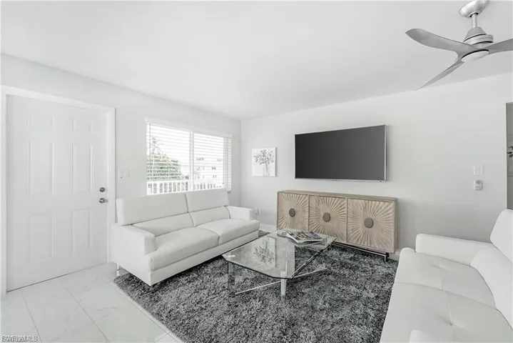 Living room featuring marble look tile flooring and a ceiling fan