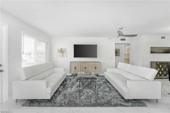 Living room with marble look tiles and a ceiling fan