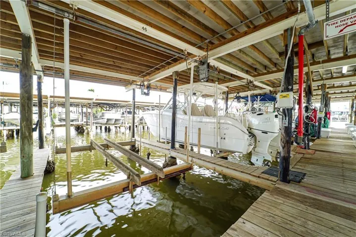 Dock area featuring boat lift and a water view