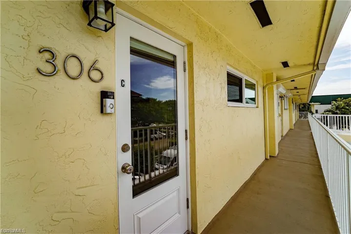 Doorway to property with stucco siding and a balcony