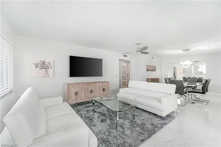 Living room featuring marble finish flooring and ceiling fan