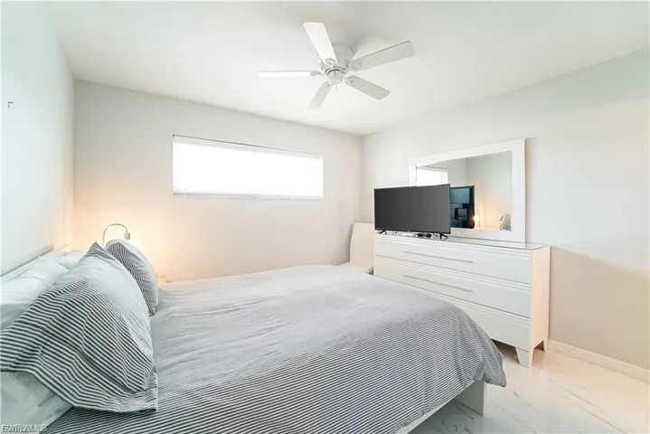 Bedroom featuring light marble finish flooring and ceiling fan