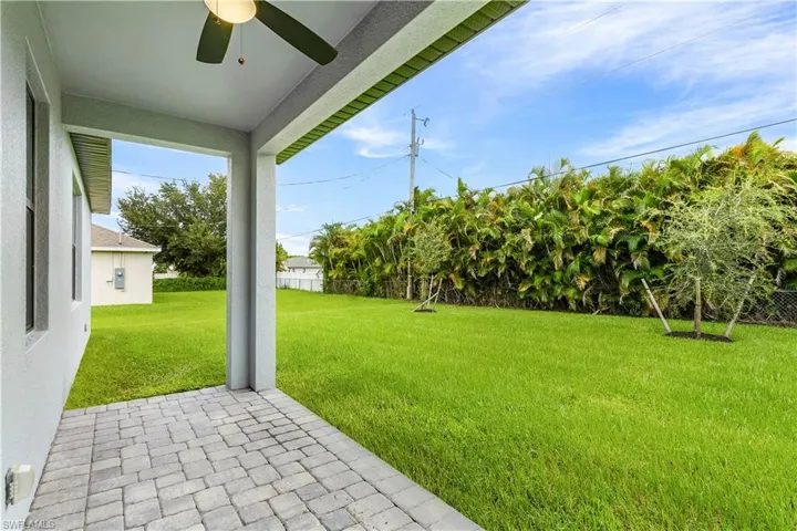 Fenced backyard featuring ceiling fan and a patio