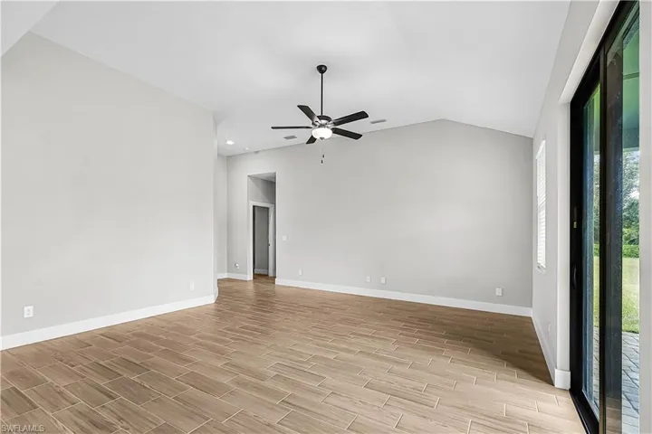 Unfurnished room featuring lofted ceiling, wood tiled floors, and ceiling fan
