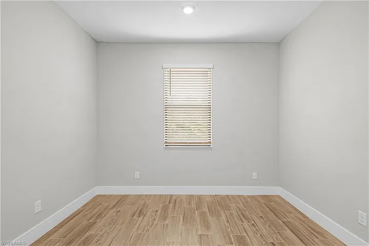 Unfurnished room with wood finish floors and baseboards