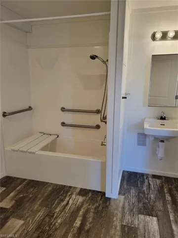 Full bath with wood finished floors, visible vents, and  shower combination