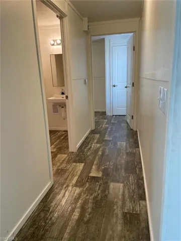 Hall with baseboards and dark wood finished floors
