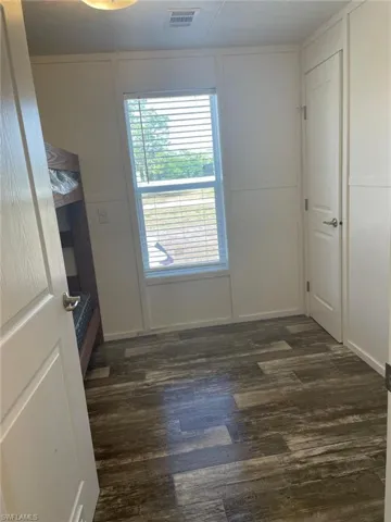 Spare room with visible vents and dark wood-style floors