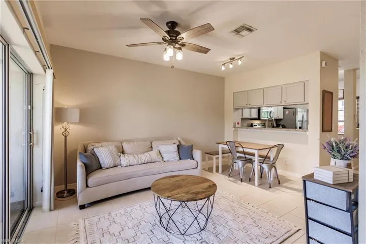 Tiled living room with ceiling fan and rail lighting
