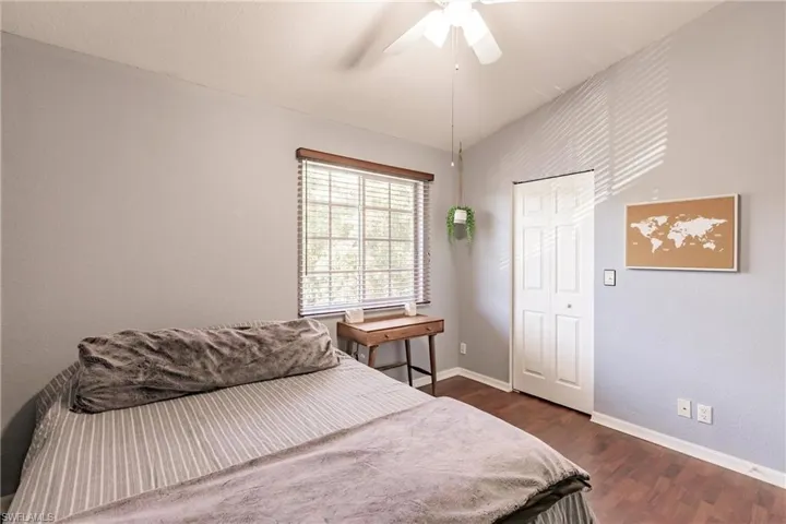 Bedroom with ceiling fan and dark hardwood / wood-style flooring