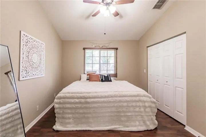 Bedroom featuring vaulted ceiling, a closet, ceiling fan, and dark hardwood / wood-style floors