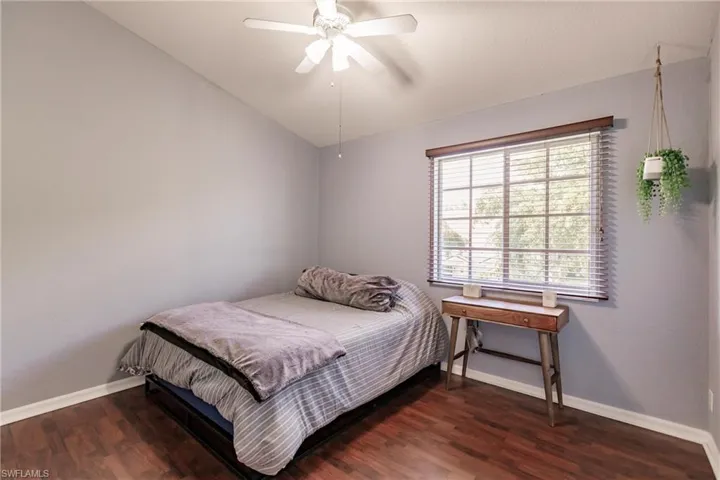 Bedroom with vaulted ceiling, hardwood / wood-style floors, and ceiling fan