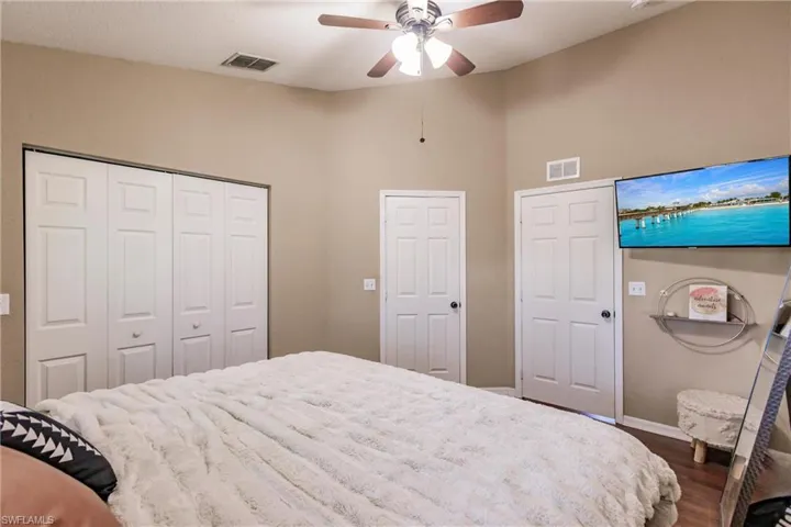 Bedroom with dark hardwood / wood-style flooring and ceiling fan