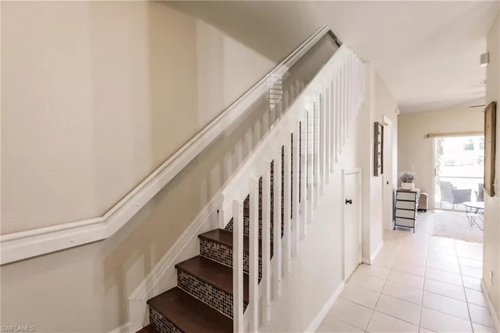 Staircase featuring light tile floors