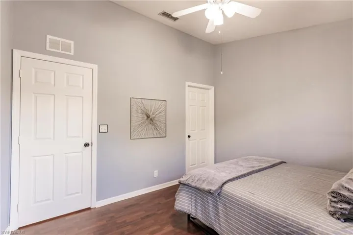 Bedroom with ceiling fan and dark wood-type flooring