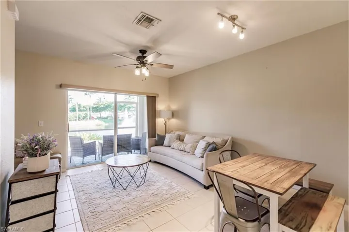 Tiled living room featuring ceiling fan and rail lighting
