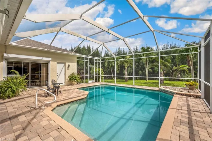 View of swimming pool featuring a patio and a lanai
