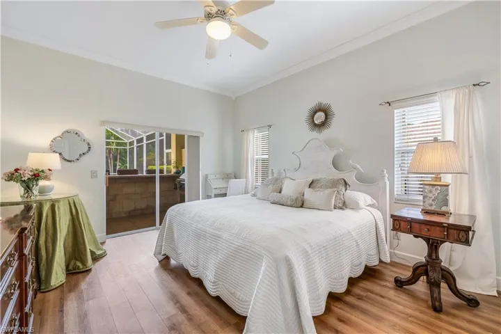Bedroom featuring hardwood / wood-style flooring, crown molding, access to exterior, and ceiling fan