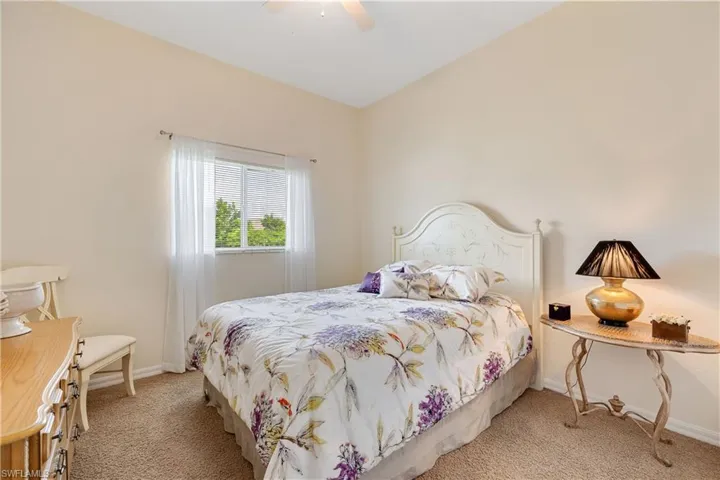 Bedroom with light colored carpet and ceiling fan