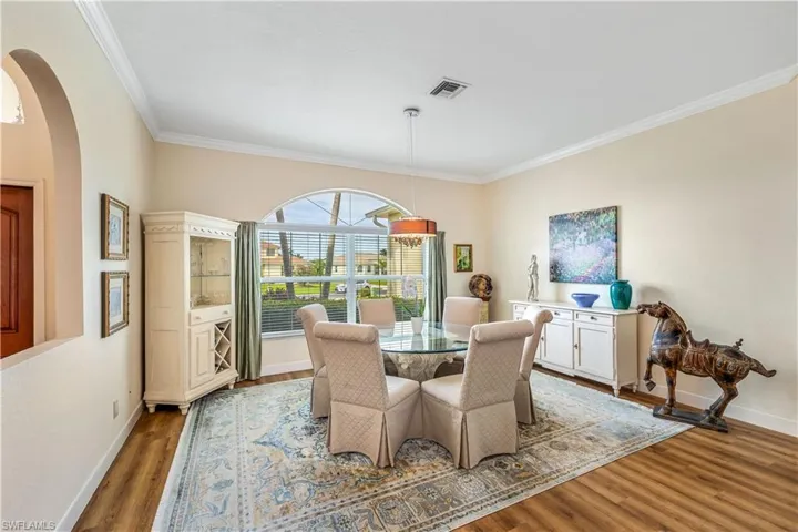 Dining area with hardwood / wood-style floors and ornamental molding