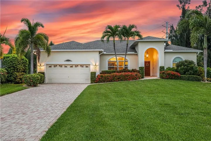 View of front of house with a garage and a yard