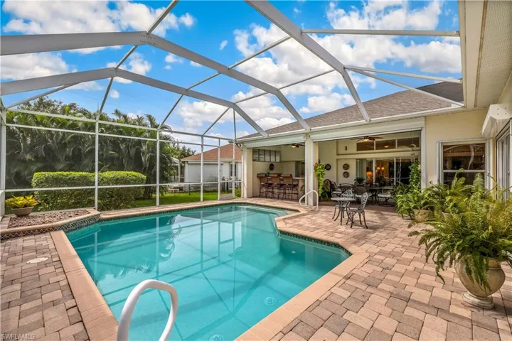 View of pool with a lanai, a patio area, and ceiling fan