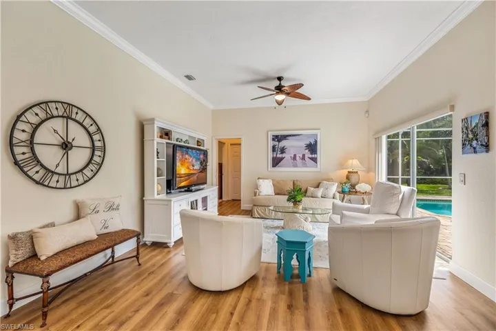 Living room featuring ceiling fan, light hardwood / wood-style flooring, and ornamental molding