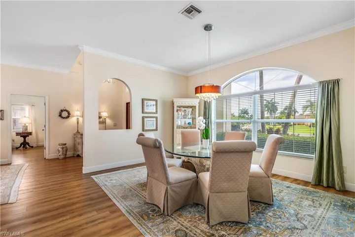 Dining space with crown molding and hardwood / wood-style floors