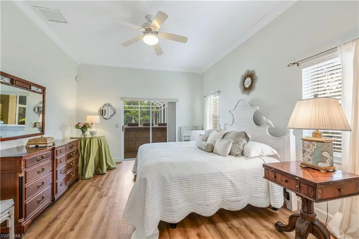Bedroom with access to exterior, ceiling fan, light hardwood / wood-style flooring, and ornamental molding