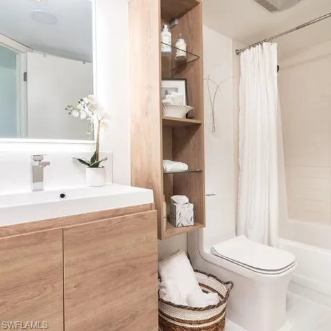 Full bathroom with shower / tub combo, vanity, and toilet