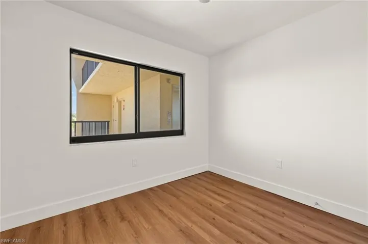 Unfurnished room featuring baseboards and wood finished floors