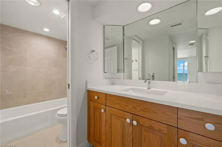 Bathroom featuring vanity, shower / bath combination, and recessed lighting