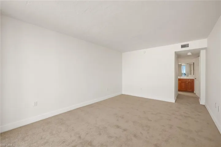 Unfurnished room featuring light colored carpet and baseboards