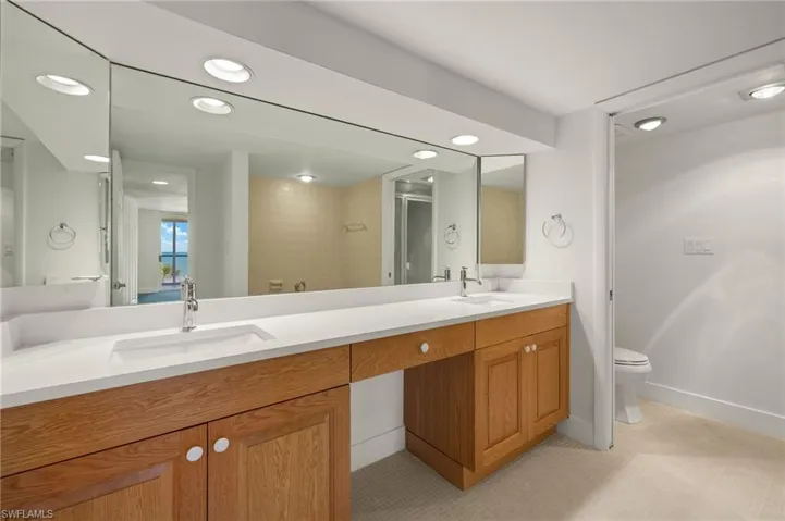 Full bathroom featuring double vanity, tiled shower, recessed lighting, and light tile patterned floors