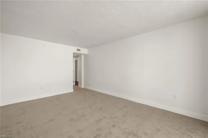 Unfurnished room with carpet and a textured ceiling