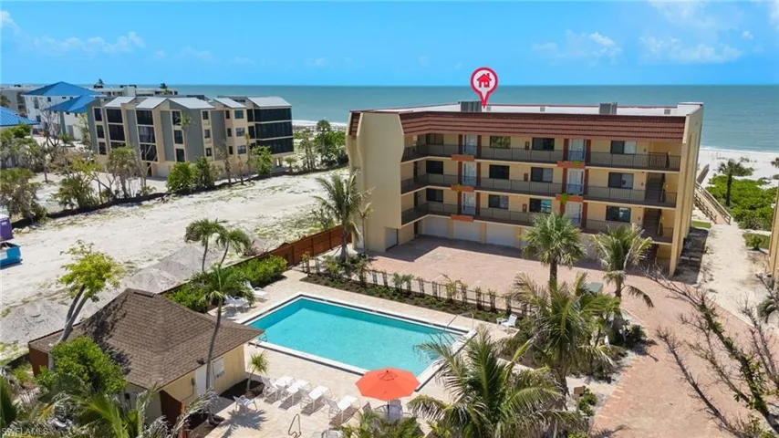 Community pool featuring a patio and view of water and beach