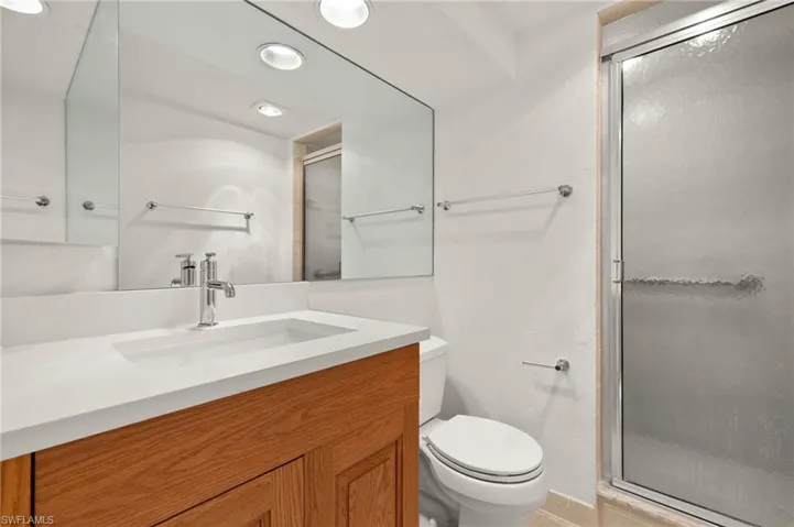 Full bath featuring a stall shower, vanity, and recessed lighting