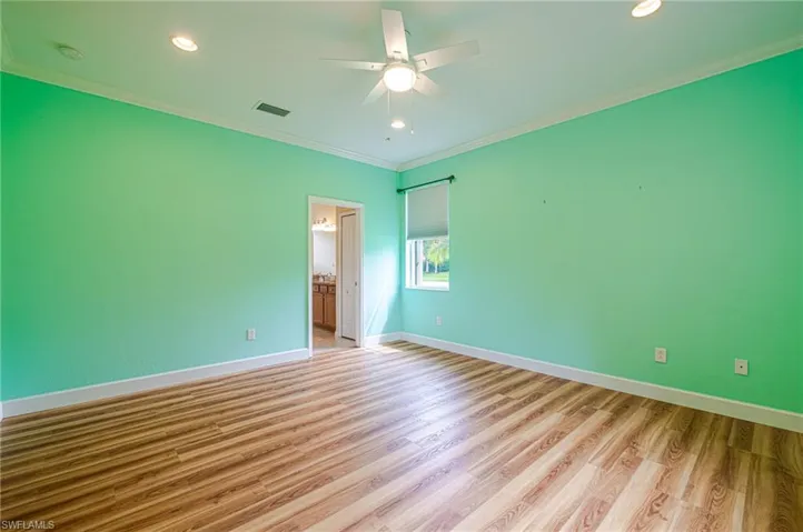 Recessed lighting, wood-finish flooring, ceiling fan, crown molding, and window with roller blind