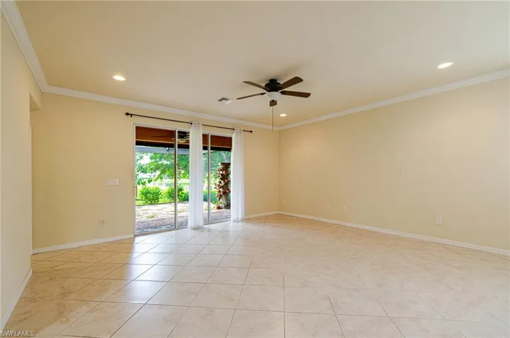 Recessed lighting, crown molding, ceiling fan, tile flooring, and sliding glass doors to outdoor patio