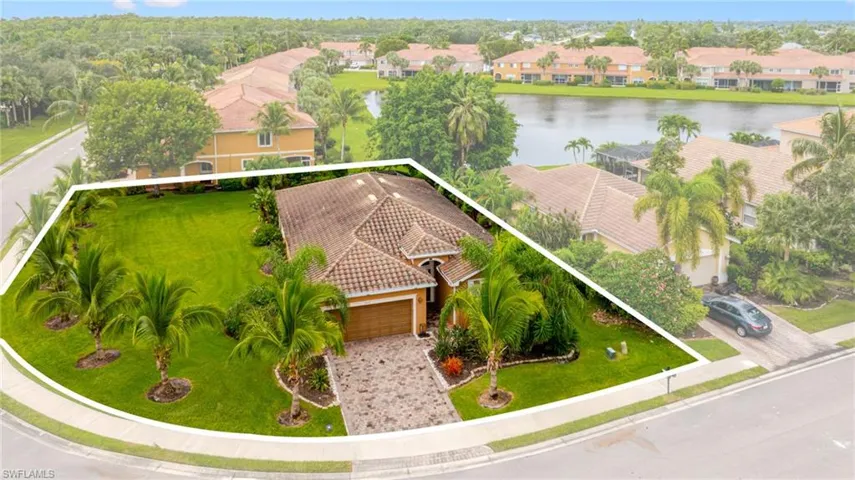 Mediterranean-inspired residence featuring a tile roof, an integrated two-car garage, and a paver driveway