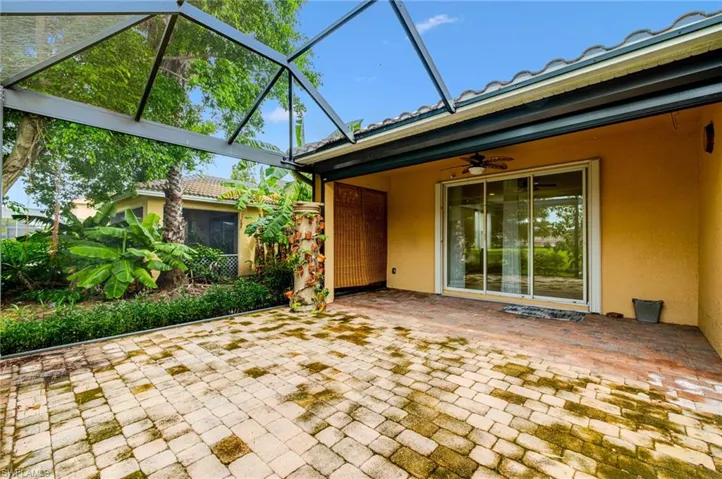 Expansive screened patio featuring paver flooring, direct outdoor access, and lush perimeter landscaping