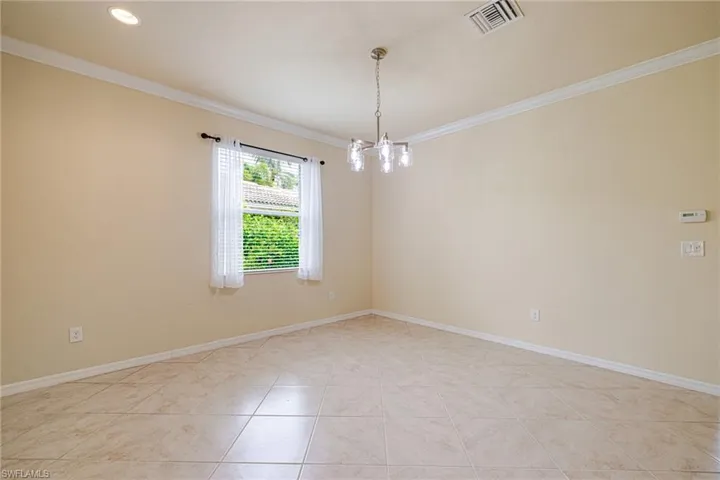 Recessed lighting, crown molding, tile flooring, and a contemporary chandelier