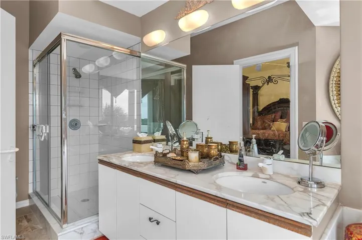 Full bath with a sink, a shower stall, and double vanity