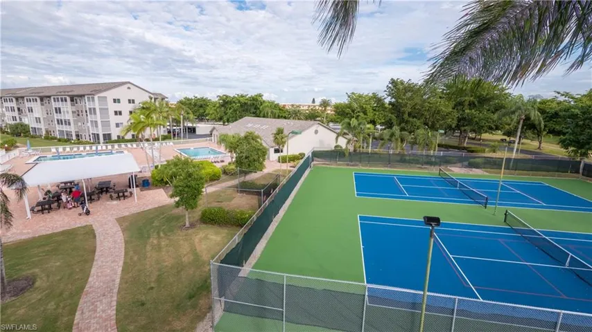 This view includes the tennis & pickle ball courts, driving cage, dining pavilion w/gas & charcoal grills, 2 of the 3 onsite pools and the clubhouse.
