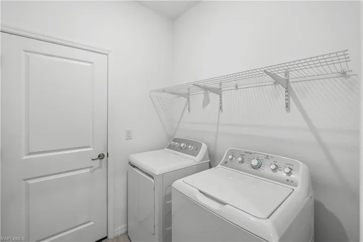 Built-in wire shelving provides storage above the laundry appliances