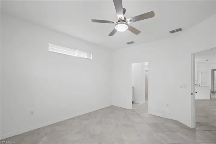 Master Bedroom continuationRecessed window, ceiling fan with integrated lighting, tile flooring, and a neutral color palette