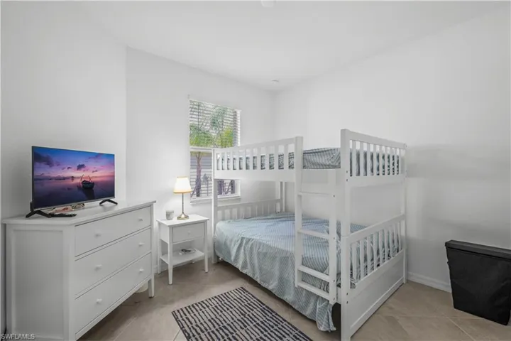 Second BedroomWhite walls featuring a window with blinds, tile flooring, and a built-in bunk bed